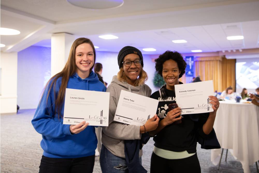 Three students posing with their I am GV certificates.